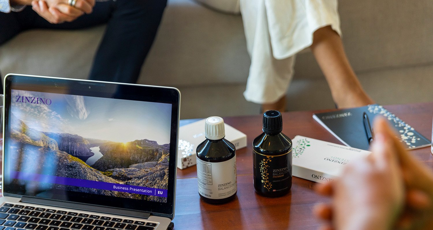 Computer and two bottles of BalanceOil+ on the table while a Zinzino customer meeting.