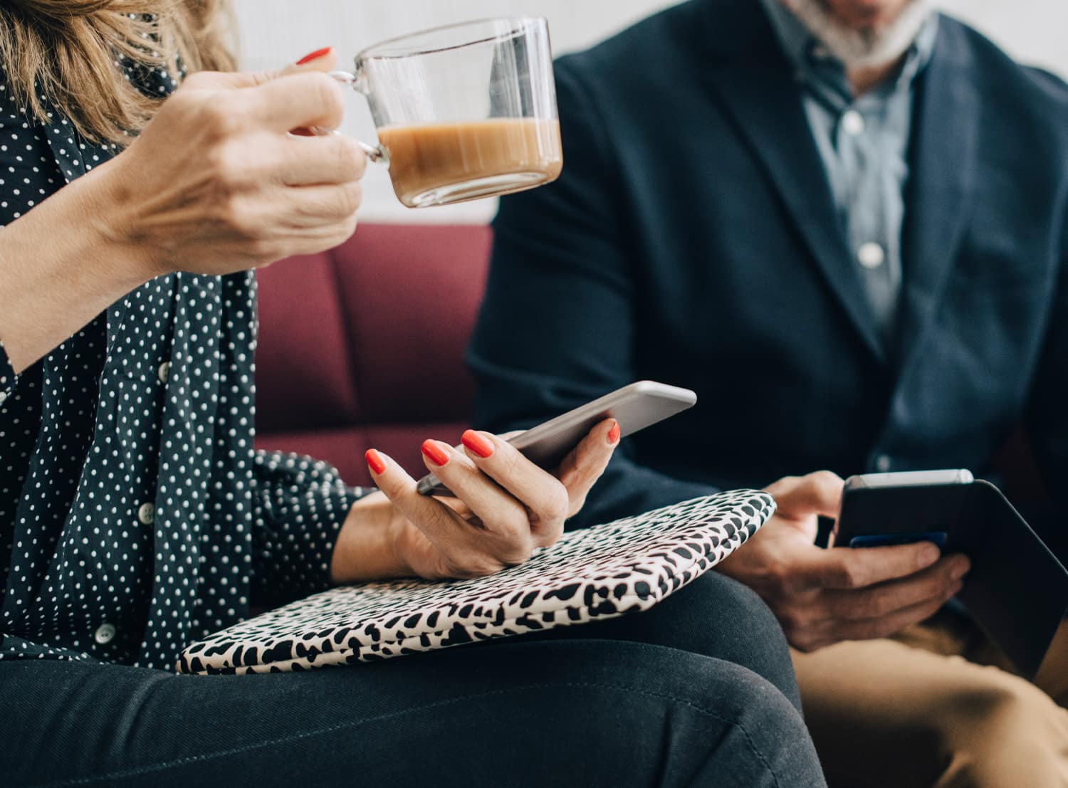 Woman holding mobile during a meeting.